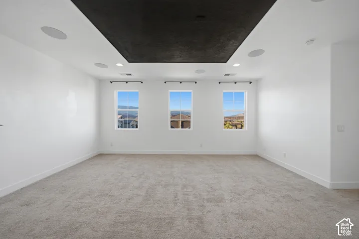 Recessed lighting, integrated ceiling speakers, and carpet flooring