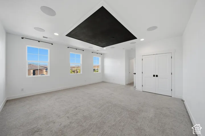 Recessed lighting, integrated ceiling speakers, and a central black ceiling accent
