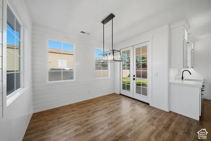 Wood-finish flooring, white shiplap walls, recessed lighting, and a linear pendant light fixture