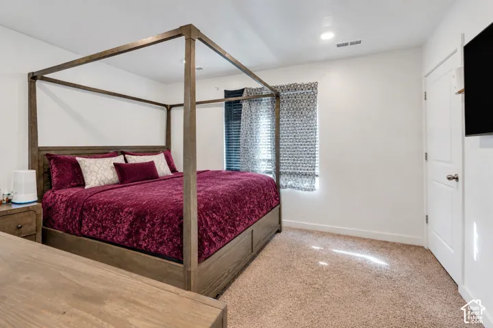 Neutral wall finishes, recessed lighting, and carpeted flooring
