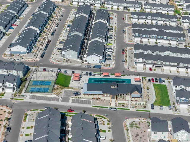 Community amenities include a multi-court sports area, a swimming pool, and a central clubhouse with covered outdoor seating