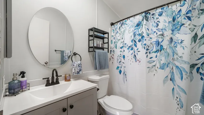 Vanity with an integrated sink, matte black faucet, and round mirror