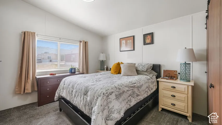 Vaulted ceiling and light gray carpeted flooring