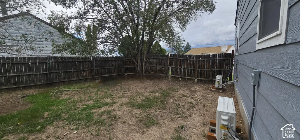 Private backyard with wood fencing, mature tree, and exterior siding
