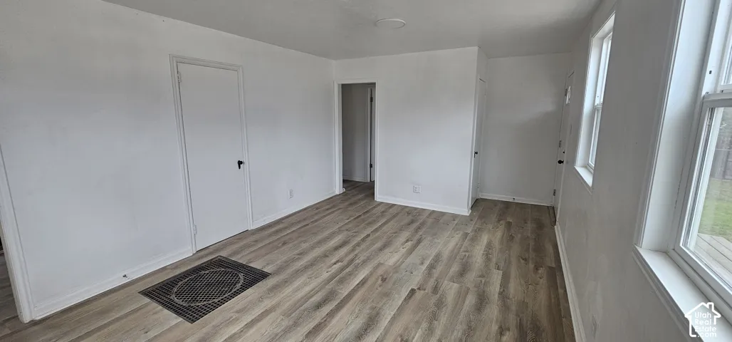 Wood-finish flooring, white walls, multiple windows, and white trim
