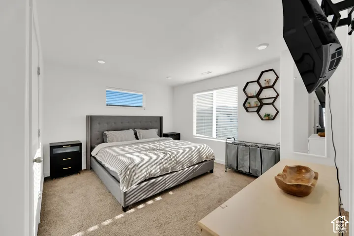 Bright room featuring carpet flooring, recessed lighting, and a large window with blinds