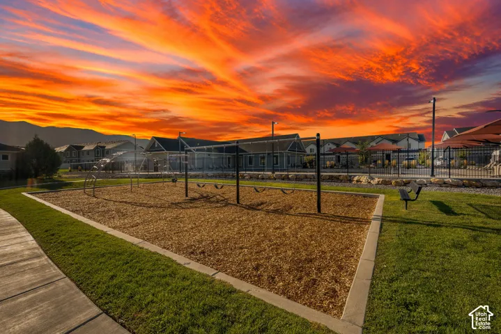 Community playground with swing sets, green spaces, and paved walking paths