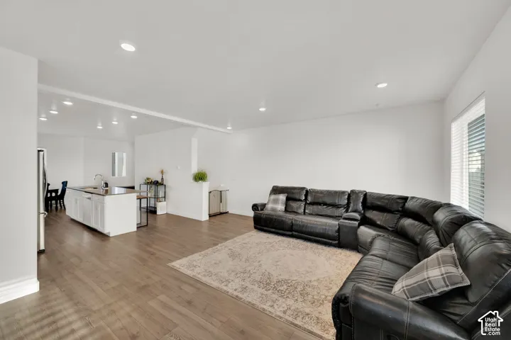 Spacious room with wood-finish flooring, recessed lighting, and white walls