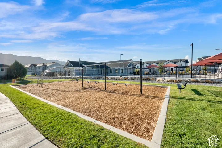 Outdoor play area with wood chip surfacing, bordered by concrete curbing