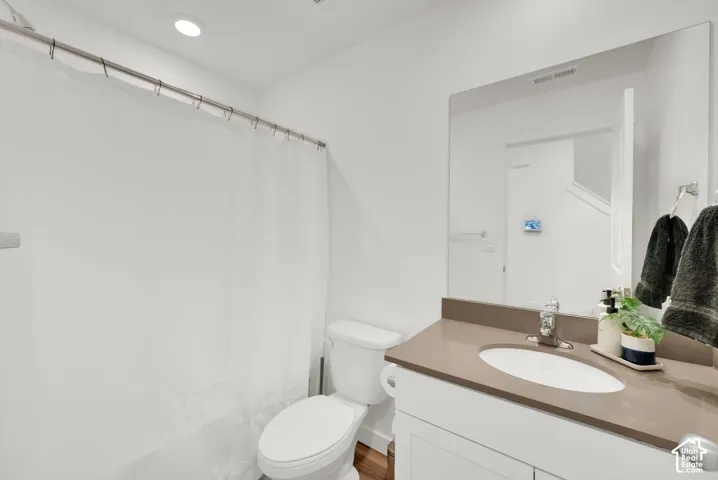 White vanity with a neutral-toned countertop and an undermount sink