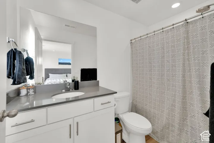 White vanity with brushed nickel hardware, undermount sink, and a gray countertop