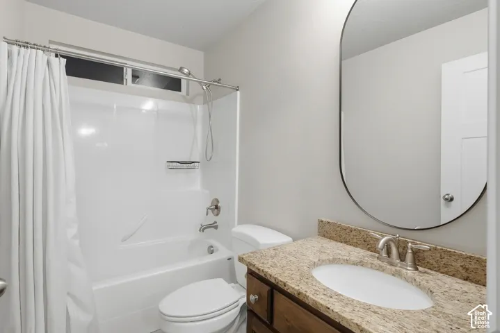 Built-in vanity with a granite countertop, undermount sink, and brushed nickel faucet