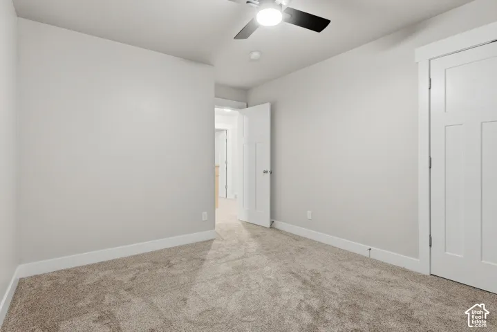 Neutral wall paint, carpeted flooring, modern ceiling fan with light, contemporary interior doors