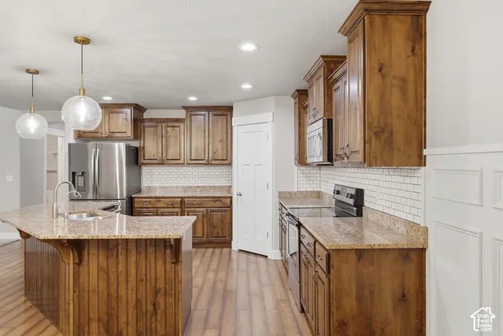 Wood-finish cabinetry paired with light-toned countertops and a subway tile backsplash