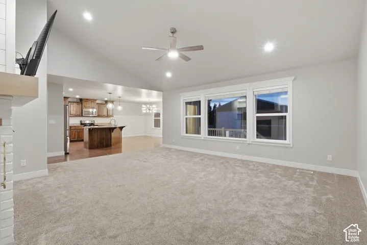 Vaulted ceilings, recessed lighting, and a ceiling fan enhance the main living space