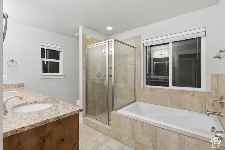 Dual vanity with undermount sinks, stone-finish countertop, and wood-finish cabinetry