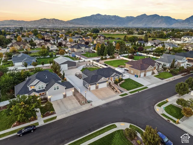 Residential neighborhood with distant mountain range, featuring established homes, paved streets, and green landscaping
