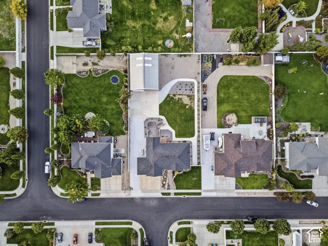 Expansive property featuring a paved driveway, a manicured lawn, established landscaping, and a substantial detached auxiliary structure