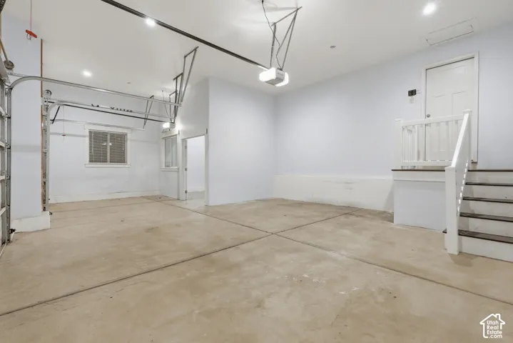 Spacious garage with concrete flooring, recessed lighting, and an overhead garage door mechanism