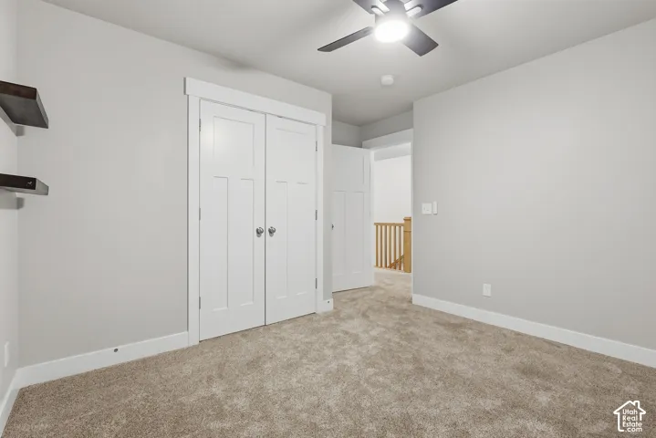 Plush carpet flooring, white trim, recessed lighting, and a ceiling fan with integrated lighting