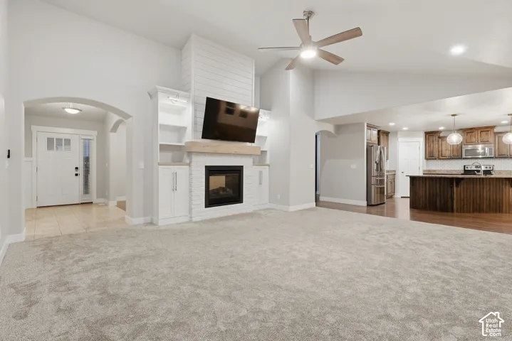 Open concept living area with vaulted ceilings and a ceiling fan