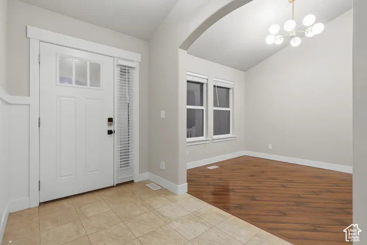 Entryway with tiled flooring and a white front door featuring transom windows