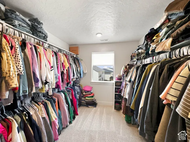 Wall-to-wall custom closet organization system with extensive hanging rods and open shelving