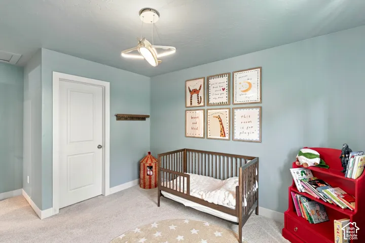 Soft blue walls with white trim, carpeting, and a built-in ceiling light fixture