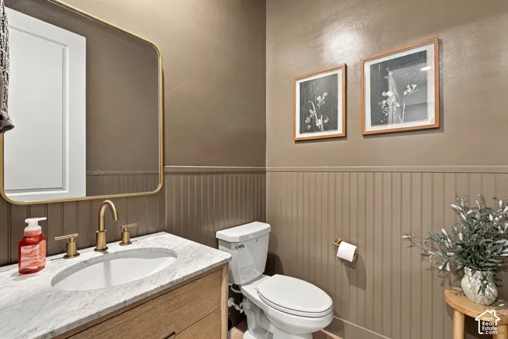 Vanity with a marble-finish countertop, undermount sink, and brass-finish faucet