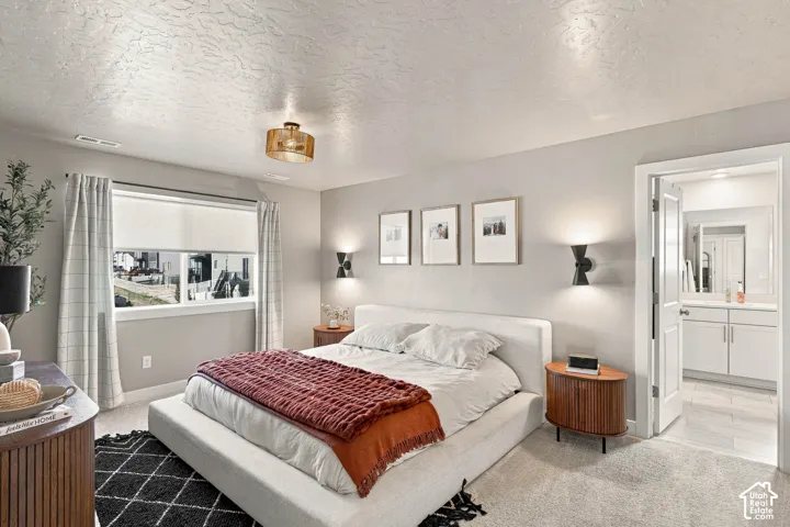 Recessed window with roller shades, ceiling-mounted light fixture, and wall-mounted sconces