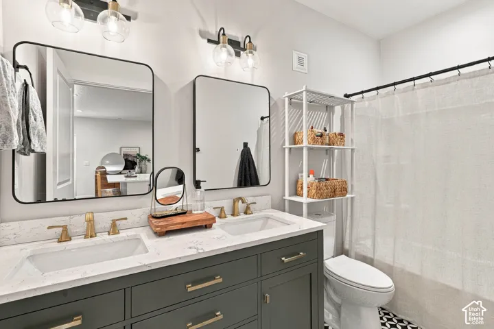 Dual vanity with gold-tone fixtures, under-mount sinks, and a light-toned countertop