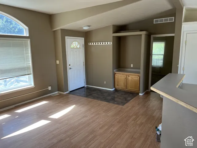 Entryway featuring a white paneled door with an arched window insert, tile flooring, and a built-in storage cabinet with a counter
