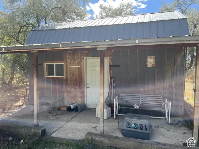 Metal roof structure with wood-paneled siding and a covered concrete porch