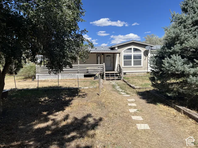 Front exterior featuring an arched window, covered porch, and metal roof