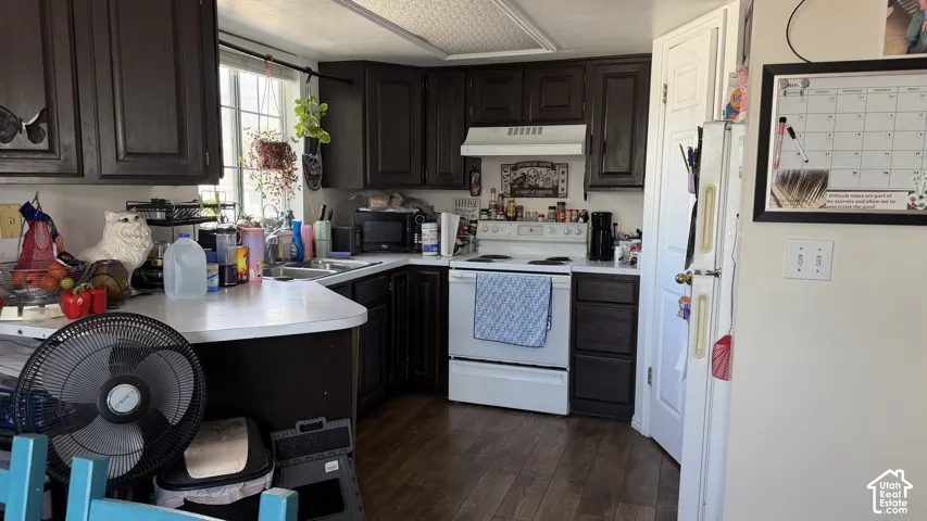 Kitchen featuring dark wood-finish cabinetry, white countertops, window with natural light, and wood-finish flooring