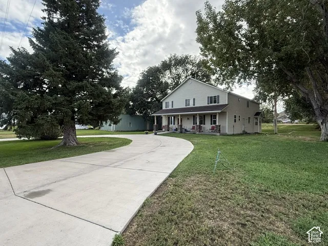 Two-story residence with a covered front porch featuring stone accents and a concrete driveway