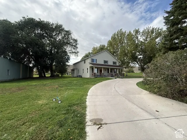 Two-story residence with a covered front porch featuring stone pillars and a concrete driveway