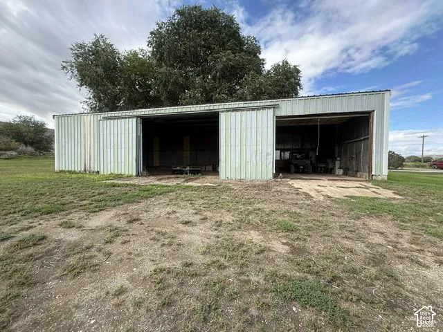 Metal-sided outbuilding with a corrugated roof and large sliding access doors