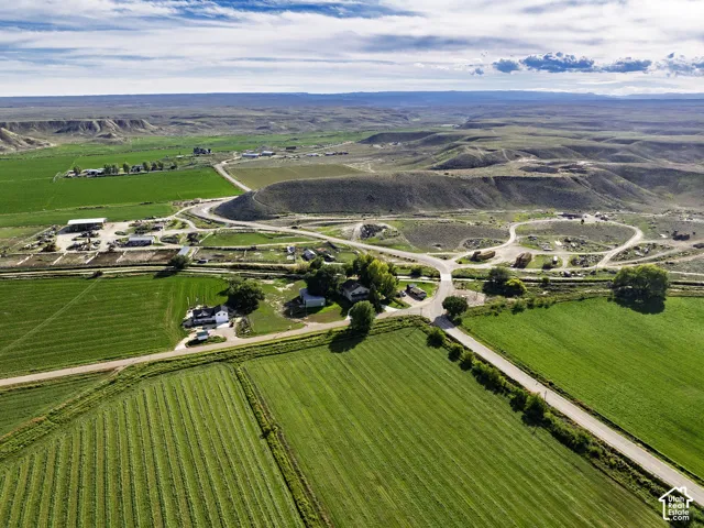 Expansive agricultural land featuring cultivated fields and surrounding natural terrain