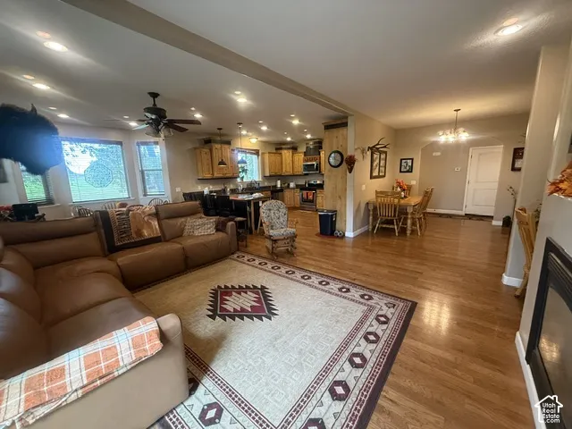 Open-concept living area featuring wood-finish flooring, recessed lighting, and a ceiling fan