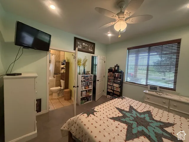 Recessed lighting, ceiling fan light fixture, wood-finish window blinds, and an attached bathroom featuring tile flooring and a shower-tub combination