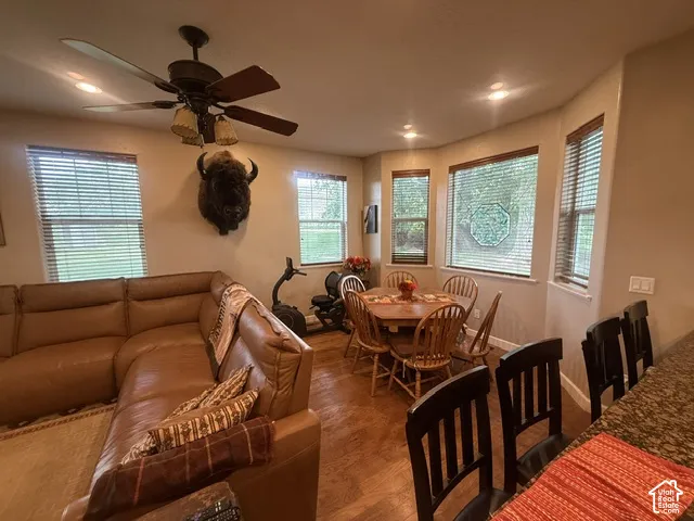 Recessed ceiling lights, wood-finish flooring, and multiple windows with blinds
