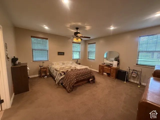 Recessed lighting, ceiling fan, carpeting, multiple windows with blinds, and neutral wall tones