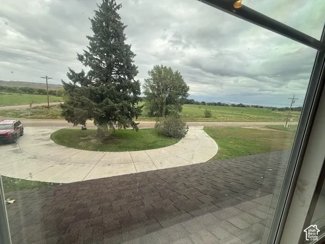 Paved circular driveway with a manicured lawn and mature trees