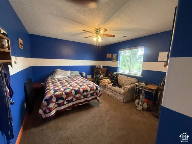 Built-in shelving, ceiling fan, window with blinds, and carpeted flooring