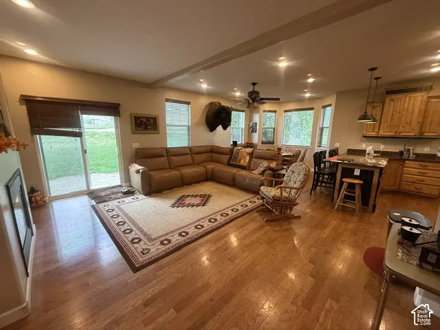 Hardwood-finish flooring, recessed lighting, sliding glass door, multi-paned windows, and a built-in kitchen island with stone-finish countertop