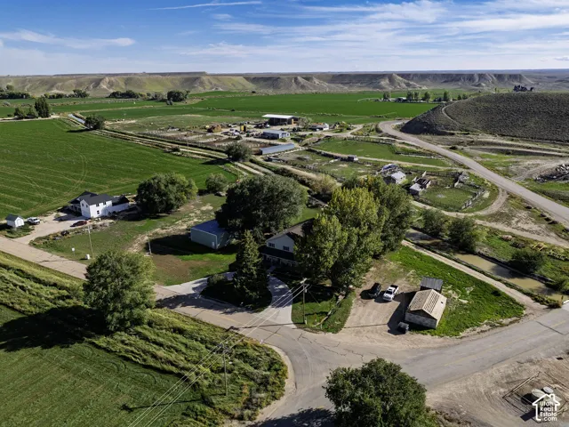 Expansive rural property featuring a main residence, multiple auxiliary structures, and surrounding green fields