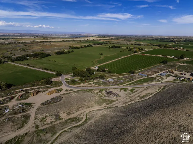 Expansive agricultural fields with distant mountains under a blue sky
