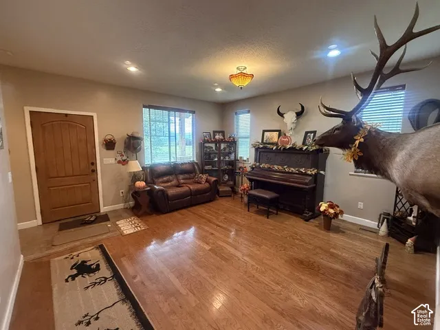 Hardwood flooring throughout, recessed lighting, and a prominent wood-panel door