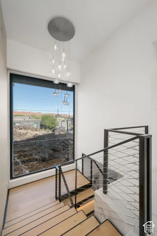 Floating staircase with wood-finish treads, a cable railing system, and a large picture window